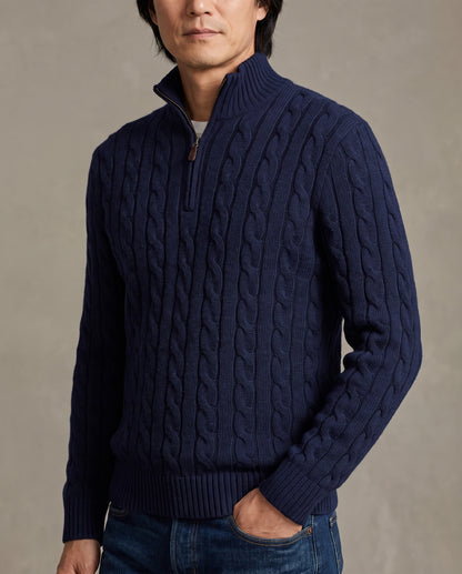 Model wearing a navy blue cable-knit quarter-zip sweater with a high mock neck
