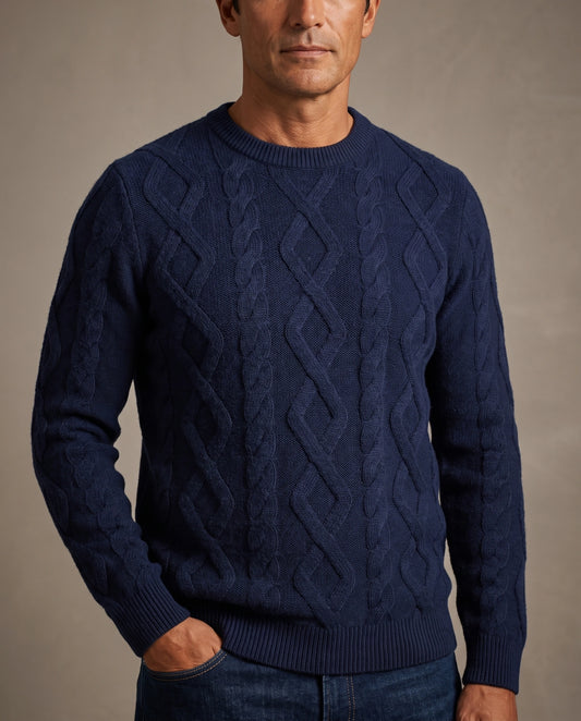 A man wearing a navy blue cable-knit crewneck sweater