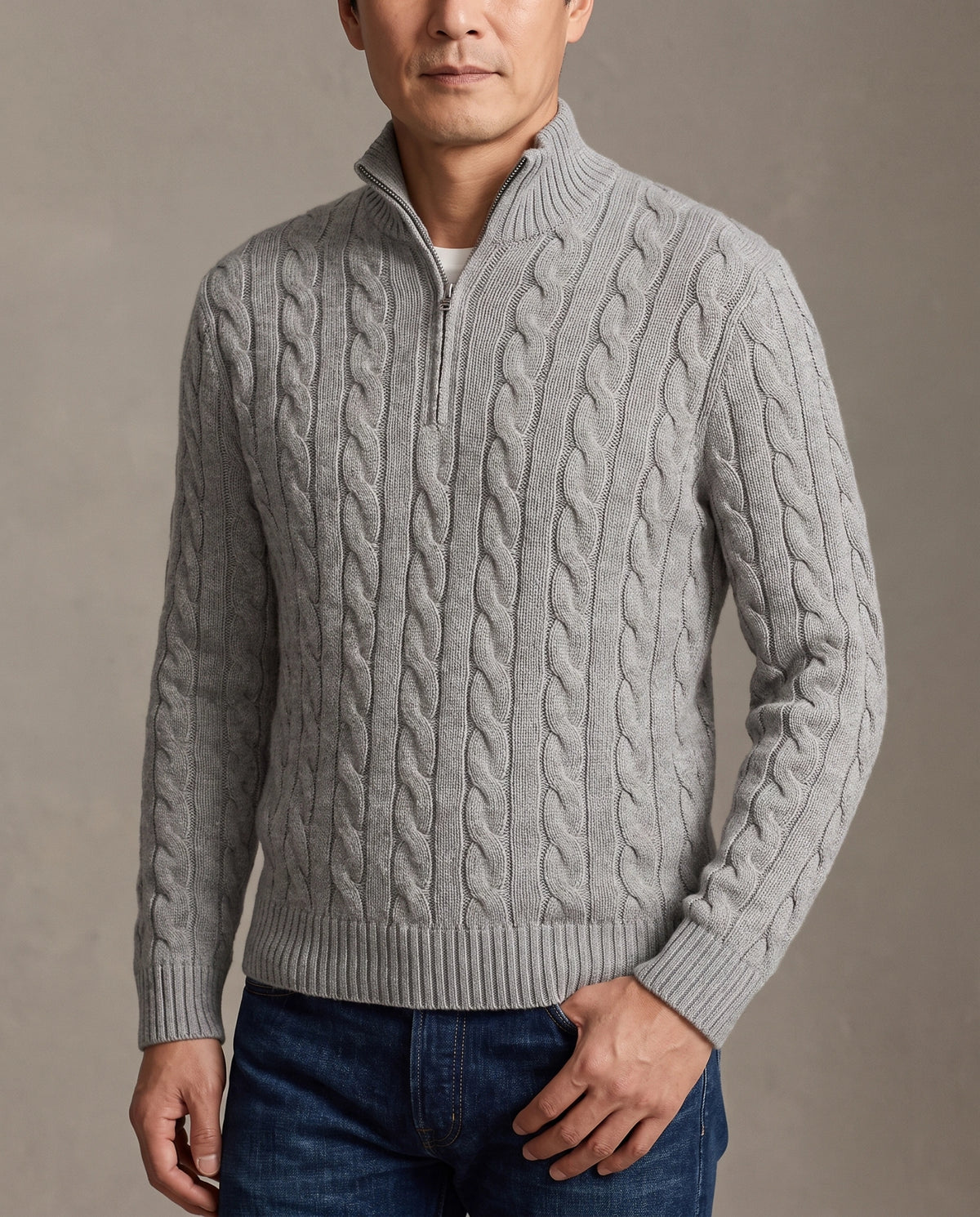 Model wearing a grey cable-knit quarter-zip sweater with a stand collar